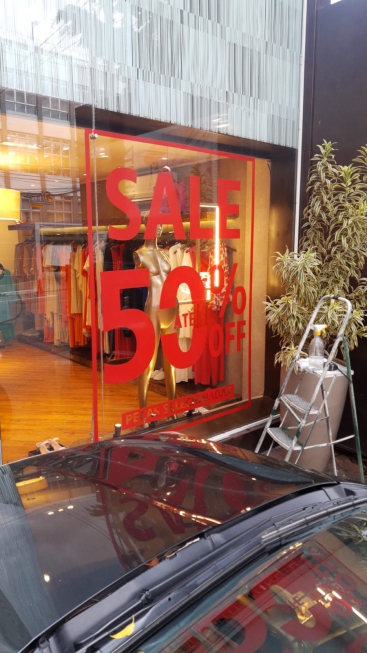 Vitrine de loja com adesivo promocional Sale